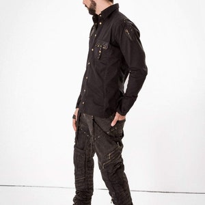May include: A black long-sleeved shirt with gold studs and a black pair of cargo pants with gold accents.