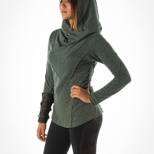 May include: A green hooded sweatshirt with a cowl neck and long sleeves. The sweatshirt has a relaxed fit and a slightly distressed look.