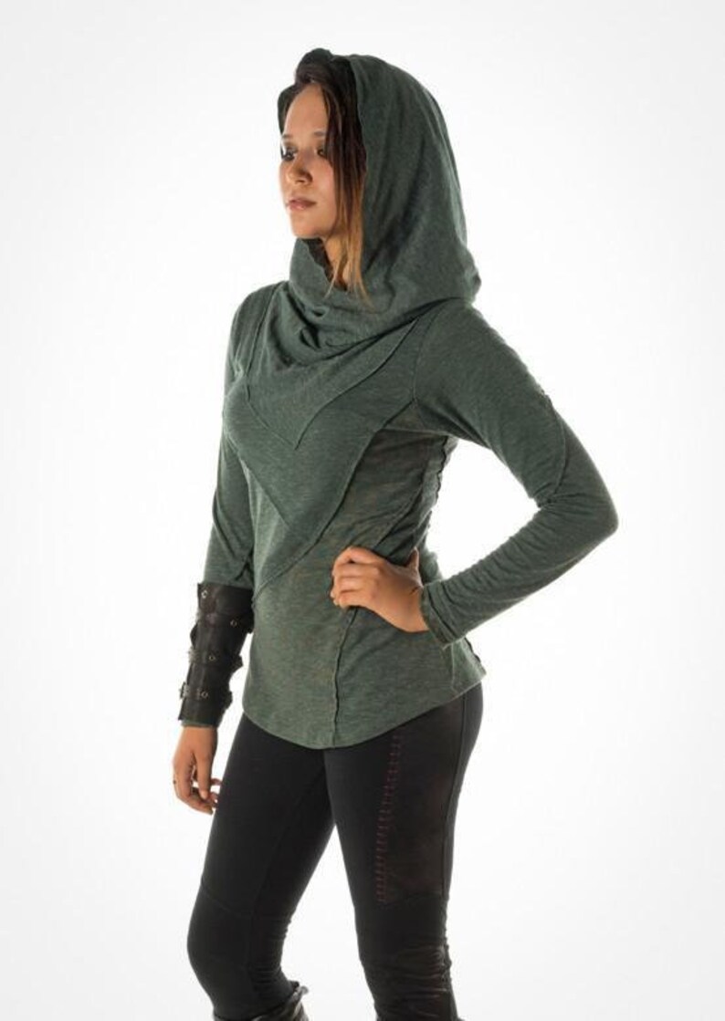 May include: A green hooded sweatshirt with a cowl neck and long sleeves. The sweatshirt has a relaxed fit and a slightly distressed look.