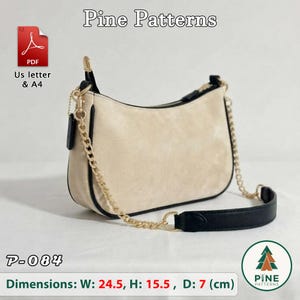 Può includere: Una borsa a spalla beige con bordi neri e una catena dorata. La borsa presenta una chiusura a zip e una spallina in pelle nera. Il testo include Pine Patterns, P-084, e le dimensioni W: 24.5, H: 15.5, D: 7 cm.