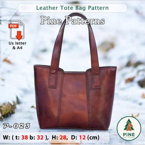 Op de afbeelding: Een bruin leren tote bag patroon met de tekst "Leather Tote Bag Pattern" en "Pine Patterns". De tas is 38 cm breed aan de bovenkant, 32 cm breed aan de onderkant, 28 cm hoog en 12 cm diep. Inclusief PDF download.