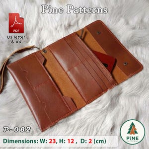 Peut inclure: Un portefeuille en cuir marron avec plusieurs fentes pour cartes et une dragonne. Le portefeuille dispose d'une fermeture à rabat avec des boutons-pression métalliques. Le texte inclut Pine Patterns, P-082 et des dimensions de 23x12x2 cm.