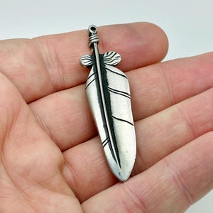 Broche de peltre con diseño de pluma tribal nativa del noroeste, estilo vintage.