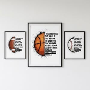Puede incluir: Conjunto de tres impresiones artísticas enmarcadas con un balón de fútbol americano, baloncesto y béisbol. Cada impresión tiene un diseño de balón deportivo con el texto "For God So Loved The World" y "Eternal Life" de Juan 3:16.