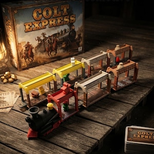 Puede incluir: El juego de mesa Colt Express con una locomotora de vapor negra y varios vagones de tren en amarillo, rojo y beige. El juego incluye una caja con una ilustración del oeste, pequeñas figuras de personajes, fichas de botín y un mazo de cartas.