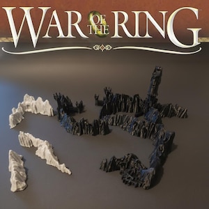 Peut inclure: Un ensemble de jeu de société avec des pièces de terrain noires et blanches, représentant des formations rocheuses et des murs de château. Le titre du jeu, "WAR OF THE RING", est affiché en haut de l'image. Idéal pour les jeux de table.