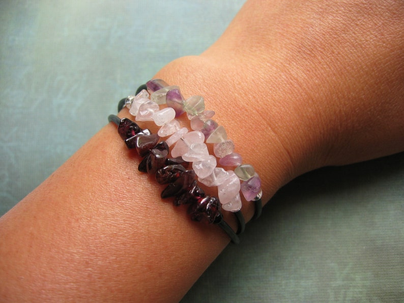 Pu&ograve; includere: Tre braccialetti sovrapposti con chip di pietre preziose di diversi colori. Lo strato superiore &egrave; verde e viola, lo strato intermedio &egrave; rosa e lo strato inferiore &egrave; rosso scuro.