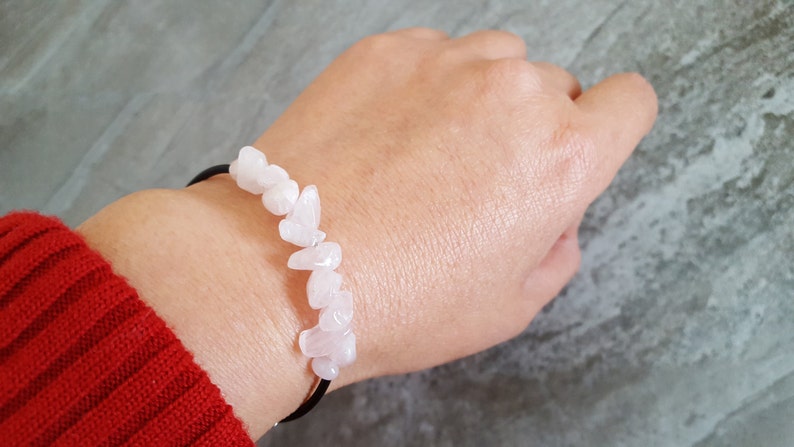 Pu&ograve; includere: Un braccialetto fatto di pietre di quarzo rosa infilate su un cordoncino elastico nero.