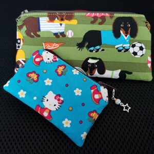 May include: Two zippered pouches, one green with a pattern of dachshunds playing soccer, and one blue with a pattern of Hello Kitty and butterflies.
