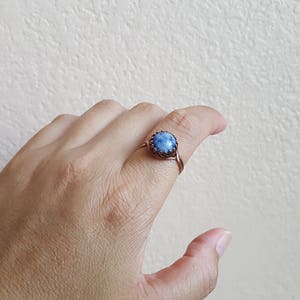 May include: A copper wire ring with a blue gemstone set in a bezel setting.