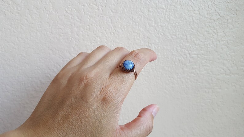 May include: A copper wire ring with a blue gemstone set in a bezel setting.