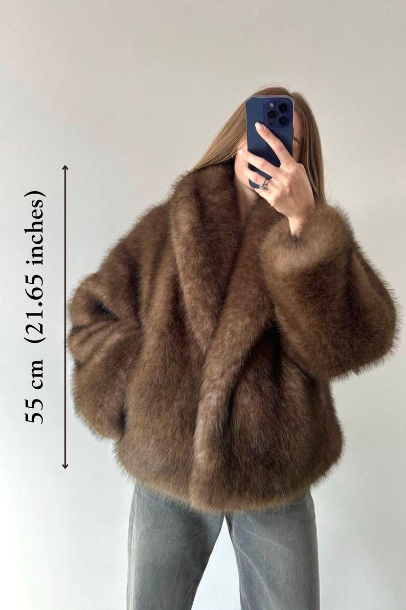 May include: Brown faux fur jacket, 21.65 inches in length, with a wide collar and long sleeves. The jacket has a soft, plush texture and a relaxed fit. A stylish outerwear piece for cooler weather.