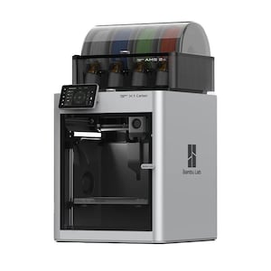 Peut inclure: Imprimante 3D argentée et noire avec une unité de stockage de filaments transparente sur le dessus. L'imprimante possède un écran tactile et le texte "X1-Carbon" et "Bambu Lab" sont visibles.