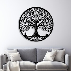 May include: A black metal wall art piece depicting a tree of life design. The tree is circular with detailed leaves, roots, and two seated figures. The artwork is mounted on a white wall above a gray sofa.