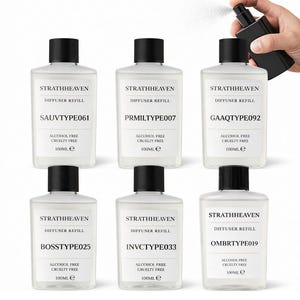 May include: Six clear glass Strathheaven diffuser refill bottles with black caps. Each bottle has a unique code and reads "Alcohol Free Cruelty Free 100ml e". One bottle is being sprayed with a black spray bottle.