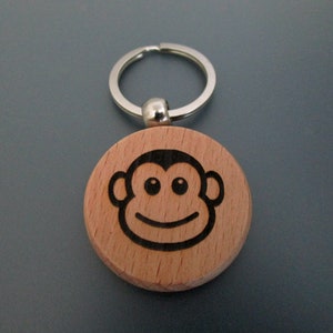 May include: A wooden keyring with a silver key ring and a laser-engraved monkey face.