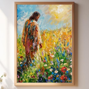 May include: A framed art print depicting a figure in a colorful robe walking through a vibrant field of wildflowers. The artwork features a warm color palette with blues, yellows, and reds. The frame is made of light-colored wood, and the scene is illuminated by sunlight.