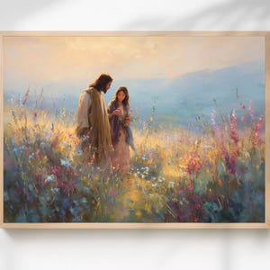 Op de afbeelding: Een ingelijste prent van een schilderij met twee figuren in een veld met wilde bloemen. Eén figuur draagt een lange, lichtgekleurde jurk, de ander een lange jurk. De achtergrond toont een zacht, heiig landschap met bergen.