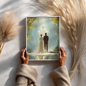 May include: A framed art print depicting a wedding scene. The artwork shows a bride and groom standing before a figure in a bright light. The bride wears a white gown and veil, and the groom is in a dark suit. The background features trees and a reflective surface.