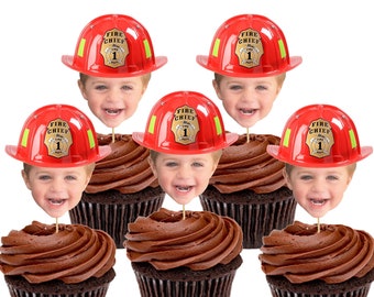 May include: Six chocolate cupcakes with chocolate frosting, each topped with a red firefighter hat and a smiling child's face. The hats have the words "Fire Chief" and the number "1".