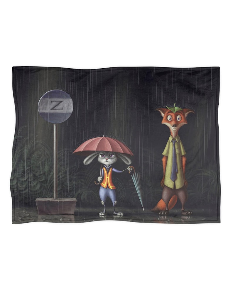 Może przedstawiać: Pluszowy koc z kresk&oacute;wkową ilustracją kr&oacute;lika i lisa stojących w deszczu pod parasolami. Kr&oacute;lik ma na sobie kamizelkę, a lis koszulę i krawat. Z tyłu znajduje się znak z literą "Z".