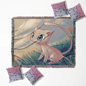 May include: A woven throw blanket and four throw pillows. The blanket features a cartoon cat in a field with blue eyes, pink fur, and a long tail. The pillows have a pink and blue design. The blanket has a fringed edge.
