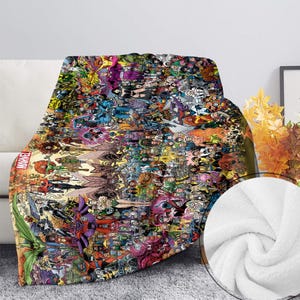 May include: A plush throw blanket featuring a collage of Marvel comic book characters in vibrant colors. The blanket displays a variety of superheroes and villains, with the Marvel logo visible. The blanket is draped over a white couch.