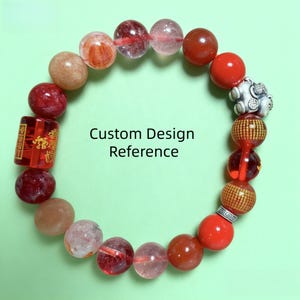 Könnte beinhalten: Ein Armband mit bunten Perlen, darunter rote, orangefarbene und transparente Kugeln. Es enthält eine zylindrische rote Perle mit goldenem Text. Der Text "Custom Design Reference" ist zu sehen.