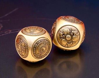 May include: Two gold-colored, spherical dice with intricate engraved designs. One die features Chinese characters and a yin-yang symbol, while the other displays a dragon motif. The dice are set against a dark background.