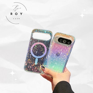 Könnte beinhalten: Zwei schillernde Handyhüllen mit Glitzer-Finish. Eine Hülle hat ein kreisförmiges Design, die andere einen Kameraausschnitt. Die Hüllen werden von einer Person gehalten. Der Markenname "ROY CASE" befindet sich oben links.