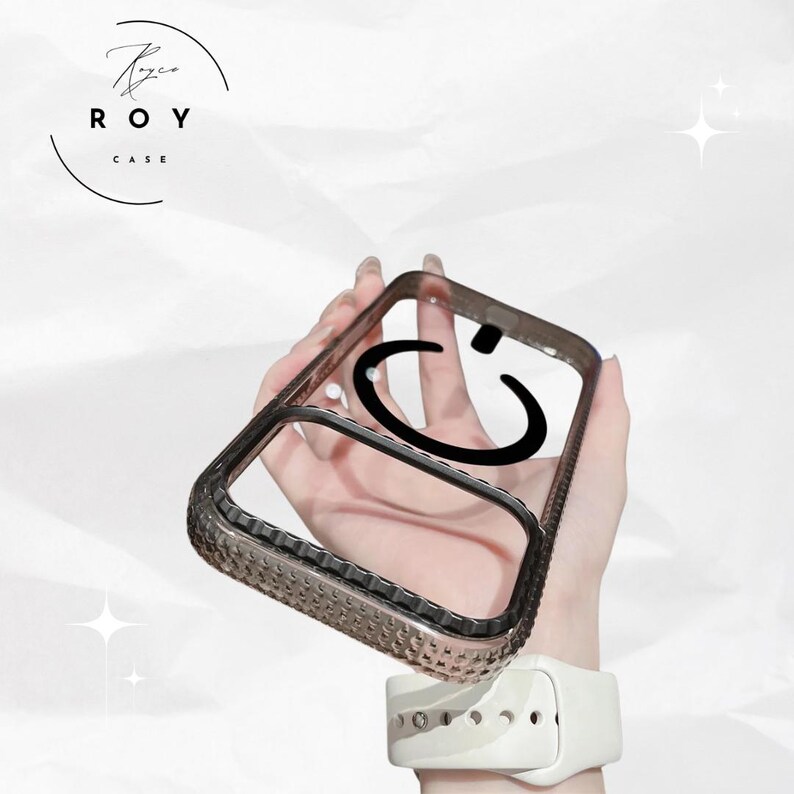 May include: A clear phone case with a black smiley face design. The case has a dark gray border with a textured pattern. The brand name "ROY CASE" is printed in a circular design in the upper left corner.