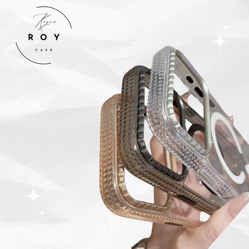 May include: A selection of clear, textured phone cases in various colors, including a light brown, dark grey, and clear case. The cases have a raised, dotted pattern and a circular magnetic component. The brand logo "ROY CASE" is visible in the upper left corner.