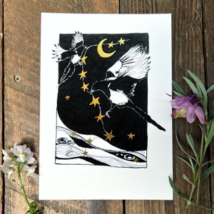 K&ouml;nnte beinhalten: Schwarz-Wei&szlig;-Illustration von zwei Elstern, die in einem Nachthimmel mit goldenen Sternen und einem Halbmond fliegen. Das Kunstwerk befindet sich auf wei&szlig;em Papier, mit dunklem Hintergrund, und wird von einer Holzoberfl&auml;che umrahmt.