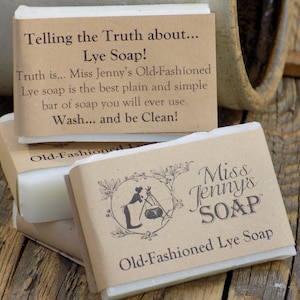 May include: Three bars of white lye soap wrapped in brown paper with a label that reads "Miss Jenny's Soap" and "Old-Fashioned Lye Soap". The top bar has a label that reads "Telling the Truth about... Lye Soap! Truth is... Miss Jenny's Old-Fashioned Lye soap is the best plain and simple bar of soap you will ever use. Wash... and be Clean!"