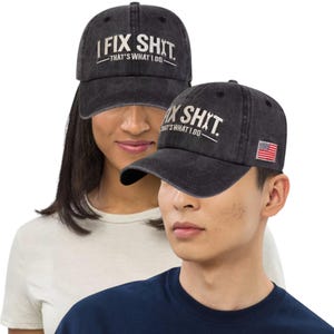 May include: Two black baseball caps with the text "I FIX SHIT - THAT'S WHAT I DO" in white. One cap has a small American flag patch. The caps are worn by two people.