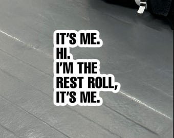 Puede incluir: Una pegatina blanca con texto negro que dice "IT'S ME. HI. I'M THE REST ROLL, IT'S ME." La pegatina está sobre una superficie gris. La pegatina es rectangular con esquinas redondeadas.