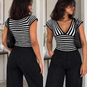May include: A short-sleeved knit top featuring a black and white horizontal striped pattern with a deep V-neckline, paired with solid black wide-leg trousers and a black shoulder bag with a silver chain strap, shown from front and back views.