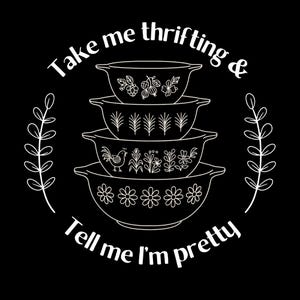 Puede incluir: Gr&aacute;fico negro con una pila de cuatro cuencos Pyrex blancos, cada uno con dise&ntilde;os florales y bot&aacute;nicos. El texto dice "Take me thrifting & Tell me I'm pretty" en c&iacute;rculo. Dos ramitas de hojas enmarcan el dise&ntilde;o.