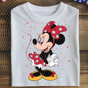 May include: White crew neck sweatshirt featuring a colorful Minnie Mouse graphic. Minnie Mouse is depicted in her classic outfit, with a red polka dot bow, dress, and shoes. The sweatshirt has a relaxed fit and is decorated with red speckles.