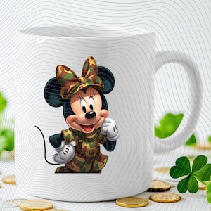 Pode incluir: Uma caneca de cer&acirc;mica branca com o gr&aacute;fico de um personagem de rato de desenho animado vestindo um vestido com padr&atilde;o de camuflagem e um la&ccedil;o a condizer. O personagem tem orelhas pretas, luvas brancas e um sorriso num fundo branco.