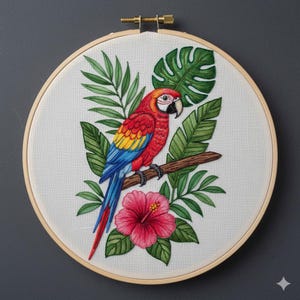 May include: Embroidered artwork featuring a vibrant macaw perched on a branch, surrounded by lush green leaves and a pink hibiscus flower. The bird has red, yellow, and blue plumage. The design is set in a wooden embroidery hoop.