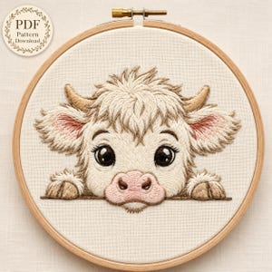 Peut inclure: Un tambour à broder contenant une pièce de tissu avec le motif brodé d'un veau Highland poilu. Le veau a une fourrure crème, des cornes fauves, de grands yeux sombres et un museau rose. Un badge circulaire indique PDF Pattern Download.