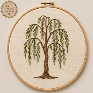 May include: A circular wooden embroidery hoop containing a piece of off-white fabric with a hand-stitched willow tree design. The tree features a textured brown trunk and roots with long, drooping branches adorned with green leaf embroidery.