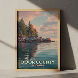 Può includere: Una stampa incorniciata con un paesaggio sereno di Door County, Wisconsin. L'opera raffigura un lago calmo che riflette un cielo colorato e una costa rocciosa con alberi sempreverdi. Il testo "DOOR COUNTY WISCONSIN" è visualizzato in basso.