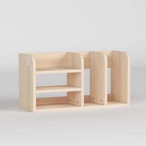 May include: A light-colored wooden desk organizer with multiple compartments. The organizer has two shelves on the left side and three vertical dividers on the right. The wood has a natural finish.