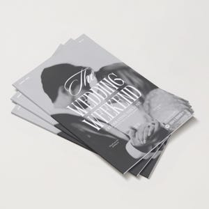 Puede incluir: Una pila de revistas con una fotografía en blanco y negro de una pareja abrazándose. El texto "The Wedding Weekend" se muestra de forma destacada en una fuente estilizada, con texto adicional debajo.