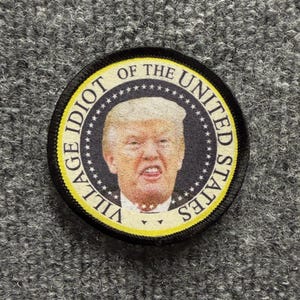 Toppa morale "Anti-Trump Village Idiot", parodia del sigillo presidenziale, chiusura a strappo (2,5" rotonda)