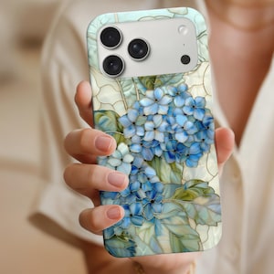May include: A smartphone case featuring a stained-glass design of blue hydrangea flowers and green leaves. The case has a light blue and white background, with a camera module at the top. The floral design is detailed and artistic.