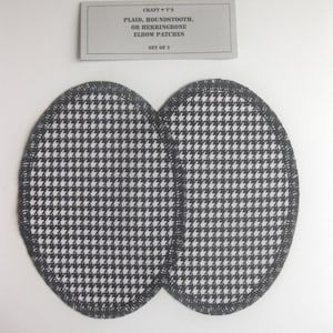May include: Two black and white houndstooth elbow patches. The patches are oval shaped and have a black stitched edge. The card reads "CRAFT ♥ T'S PLAID, HOUNDSTOOTH, OR HERRINGBONE ELBOW PATCHES SET OF 2".