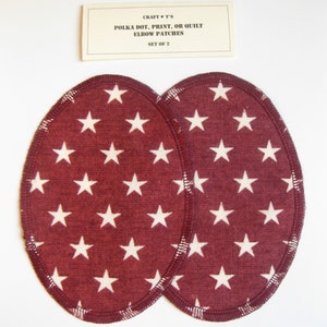 May include: Two oval elbow patches with a burgundy background and a white star pattern. The patches are edged with dark burgundy stitching. A small rectangular card above the patches reads "CRAFT V T'S POLKA DOT, PRINT, OR QUILT ELBOW PATCHES SET OF 2."